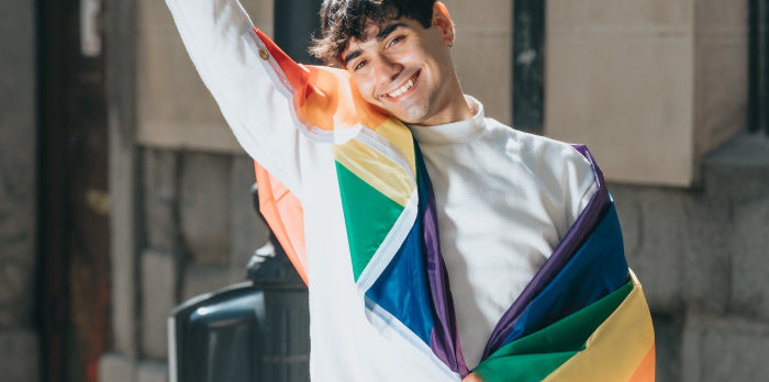 A man holding a bisexual pride flag, symbolizing visibility and pride in the face of biphobia.