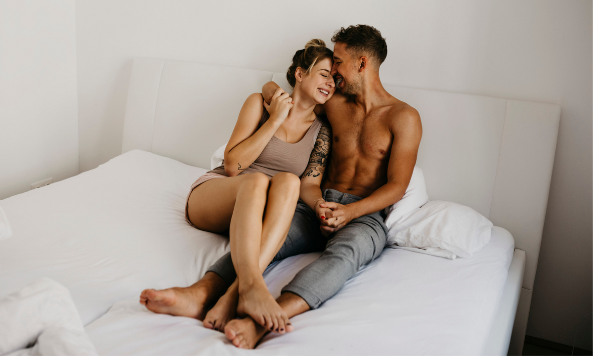 a happy couple enjoying together in bed