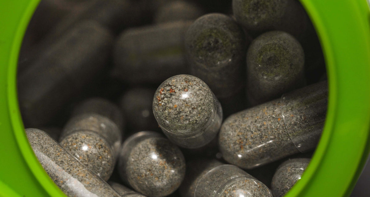 “Close-up of various supplement bottles and capsules on a wooden table, symbolizing male intimate health support.”