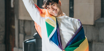 A man holding a bisexual pride flag, symbolizing visibility and pride in the face of biphobia.