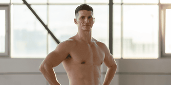 Man staring at his reflection, symbolizing internal conflict with body image and self-esteem