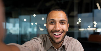 Man taking a mirror selfie in a bedroom, emphasizing his physique and confident pose before intimacy.