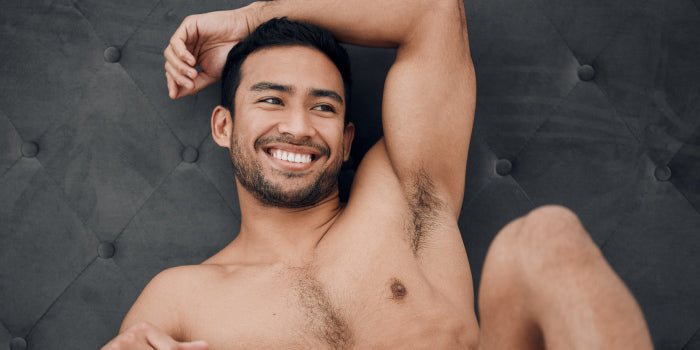 Man relaxing in a private bedroom setting with dim lighting to create the perfect environment for male masturbation.