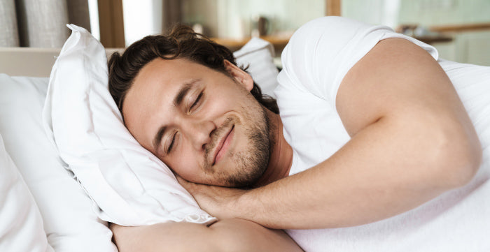 Man peacefully sleeping, representing the natural occurrence of erotic dreams during REM sleep.