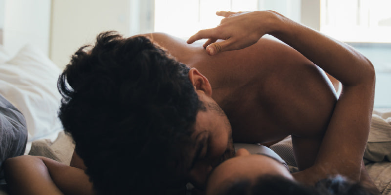 Man sitting on the edge of a bed in a calm bedroom, representing natural ways to improve sexual performance