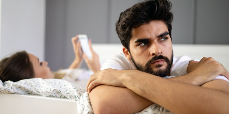 Man in bed during winter thinking about changes in erection firmness