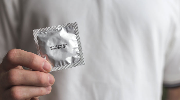 Male hand holding a condom