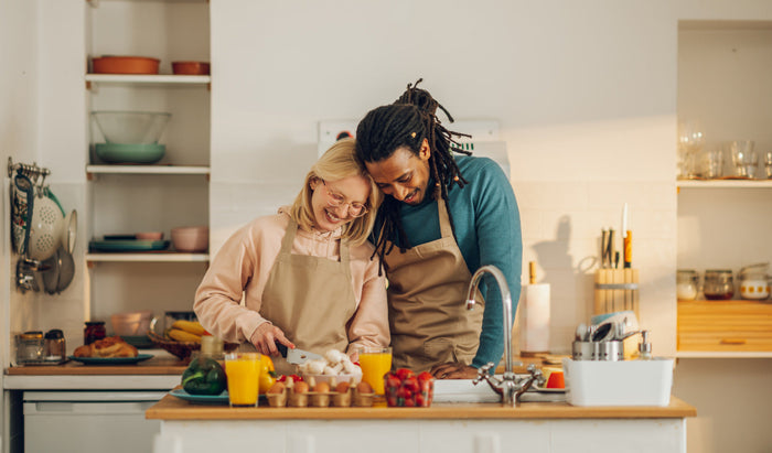 A romantic couple is cooking together at home.